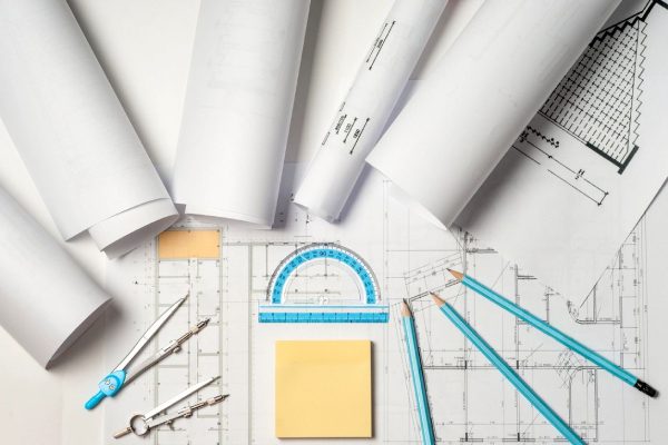 A group of construction plans and tools on top of paper.
